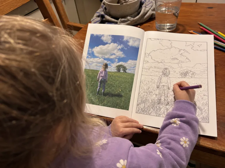 Candid parent view of a child colouring a personalised book